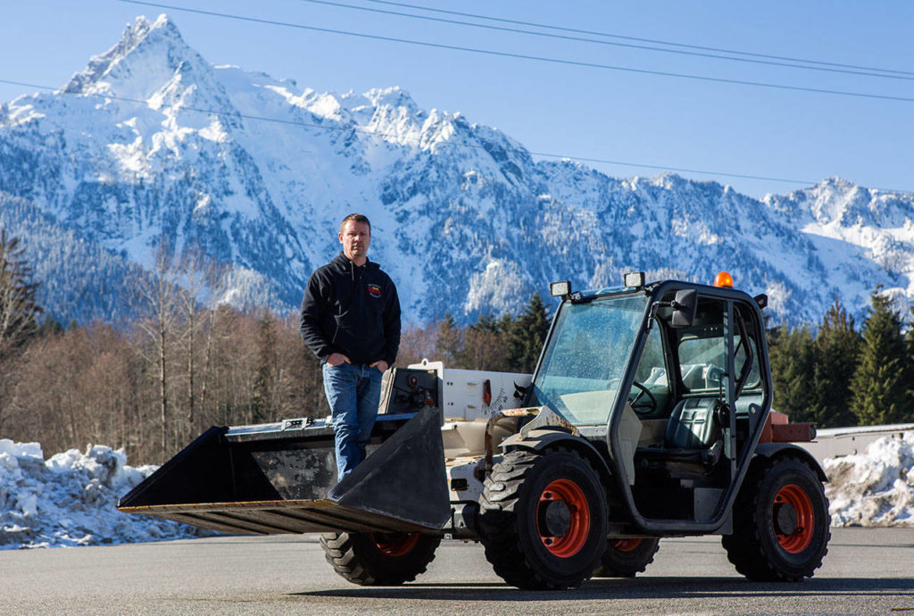 Dayn Brunner with one of the plows he has lent to help plow snow-covered roads in Darrington (Olivia Vanni / The Herald)

