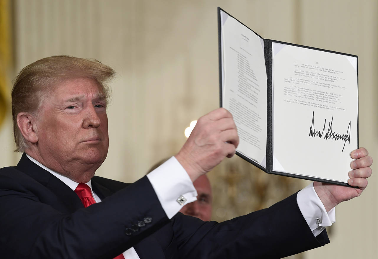 In this June 18, 2018 photo, President Donald Trump holds up the space policy directive that he signed during a National Space Council meeting in the East Room of the White House in Washington. (AP Photo/Susan Walsh, file)