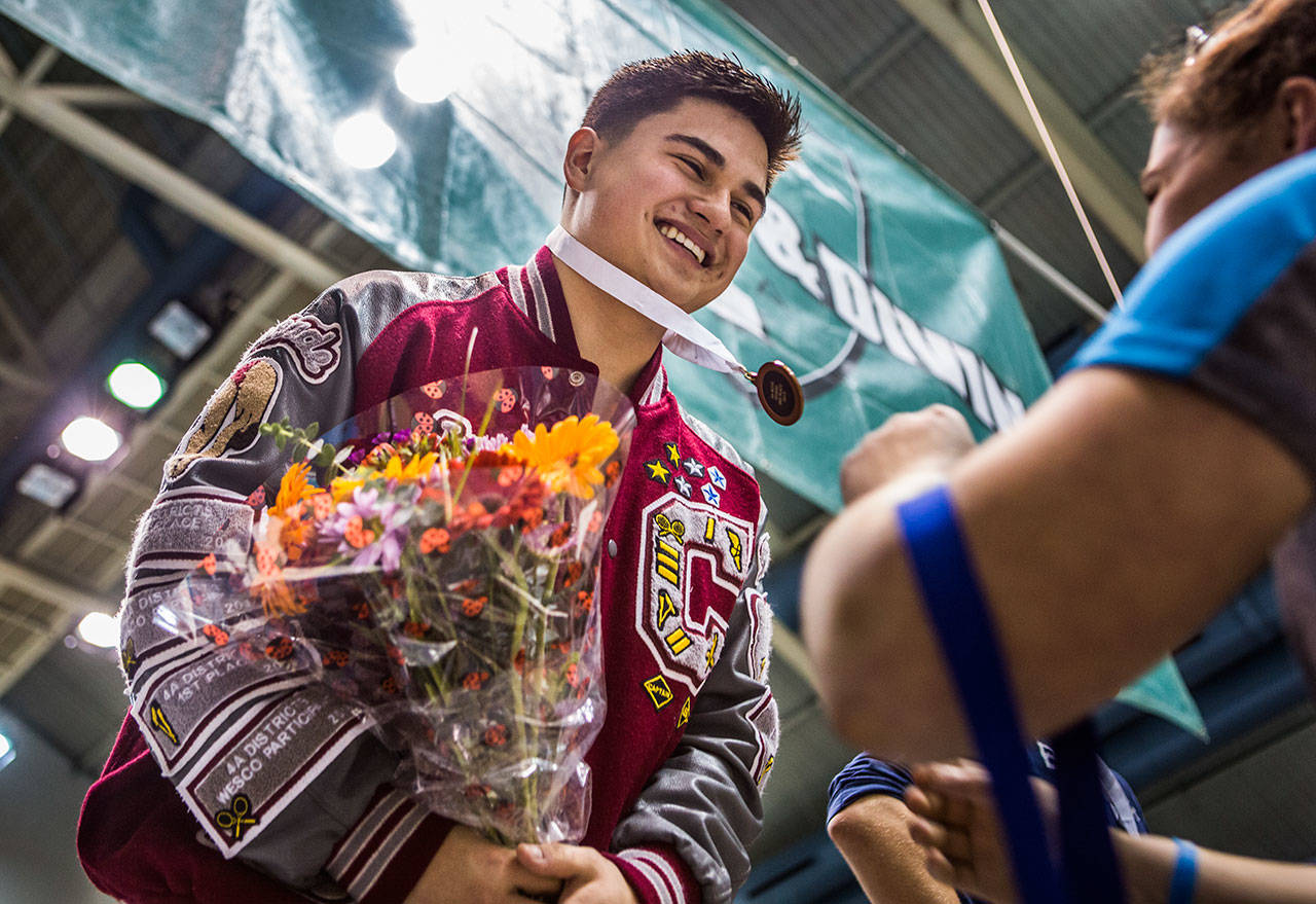 Cascade’s Joseph Hofman smiles while receiving his third place medal in Mens 1 Meter Diving during the 4A Boys’ Swim/Dive Championships on Saturday, Feb. 16, 2019 in Federal Way, Wash. (Olivia Vanni / The Herald)