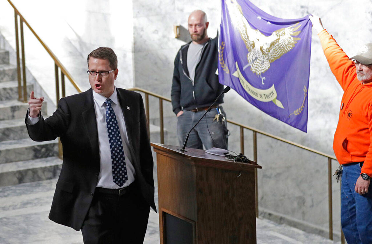 State Rep. Matt Shea, R-Spokane Valley, gestures as he gives a speech in front of the proposed Liberty state flag, Feb. 15, at the Capitol in Olympia, during a rally seeking to split Washington state into two states and questioning the legality of Washington’s I-1639 gun-control measure. (Ted S. Warren/Associated Press)