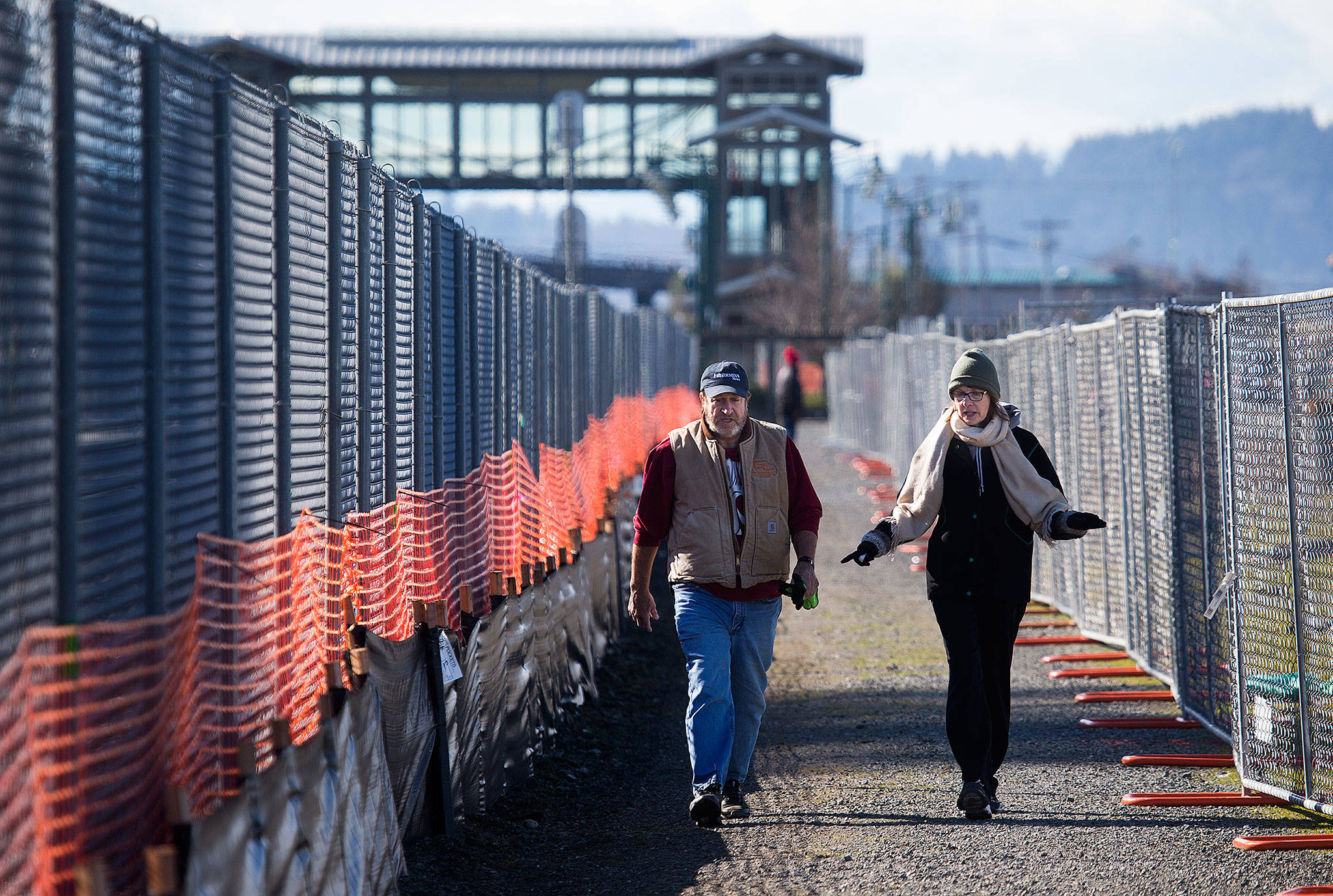 Brad and Linda Guilford chat as they walk along the pedestrian path set up around the new Mukilteo ferry dock construction. The Guilfords live on the hill above the construction and walk daily to observe the progress. (Andy Bronson / The Herald)