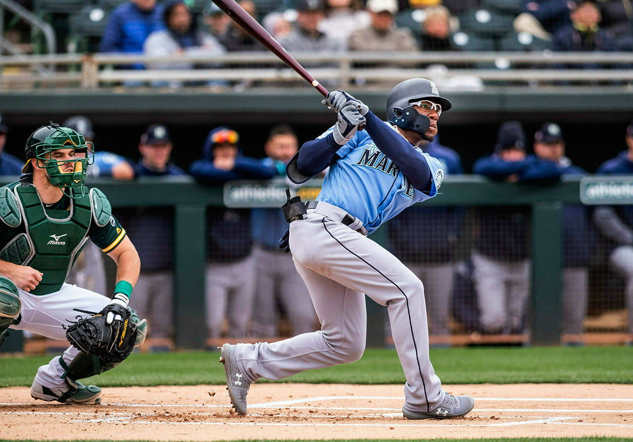 The Mariners’ Shed Long (right) doubles in the first inning during a spring game against the Athletics on Feb. 21, 2019, in Mesa, Ariz. (Dean Rutz / The Seattle Times via AP)