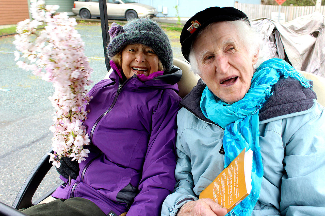 Roberta Brown, 87, and Peter Lawlor, 97, take a ride in a golf cart during last year’s Welcome the Whales parade in Langley. (Patricia Guthrie/South Whidbey Record file)