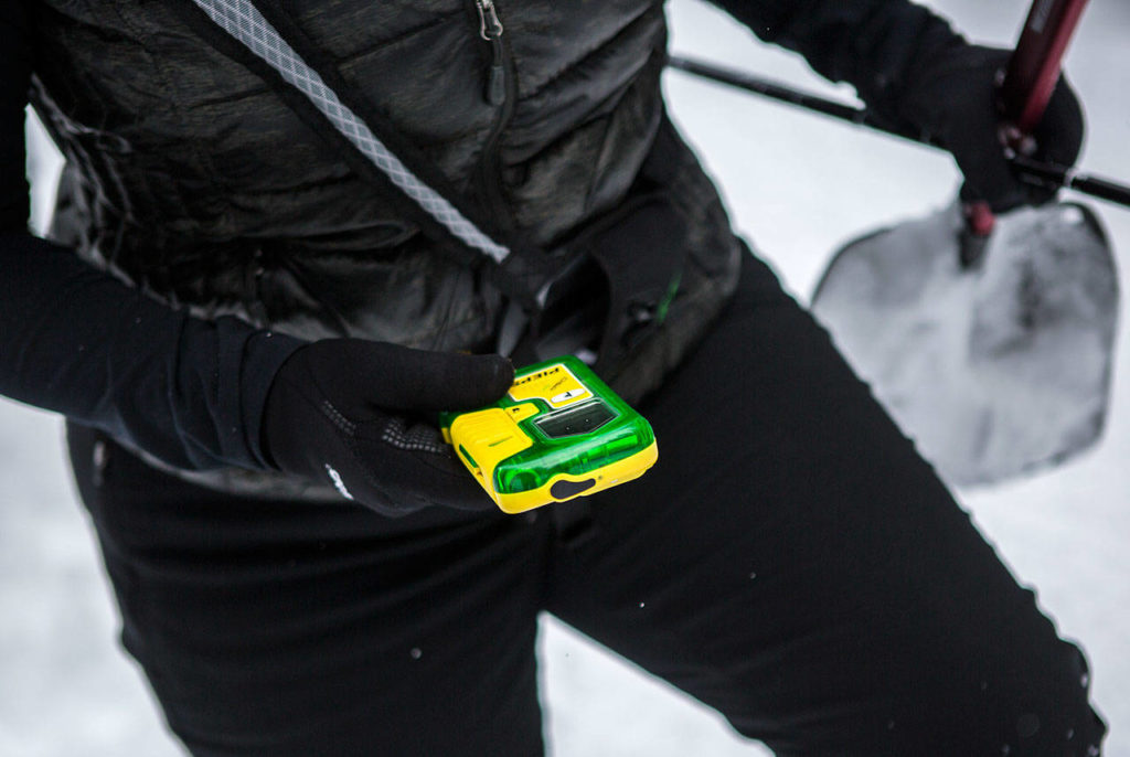 Rhonda Miller demonstrates how to use an avalanche beacon during the “Snowshoe with a Ranger” program on the Pacific Crest Trail North on Saturday near Stevens Pass. (Olivia Vanni / The Herald)
