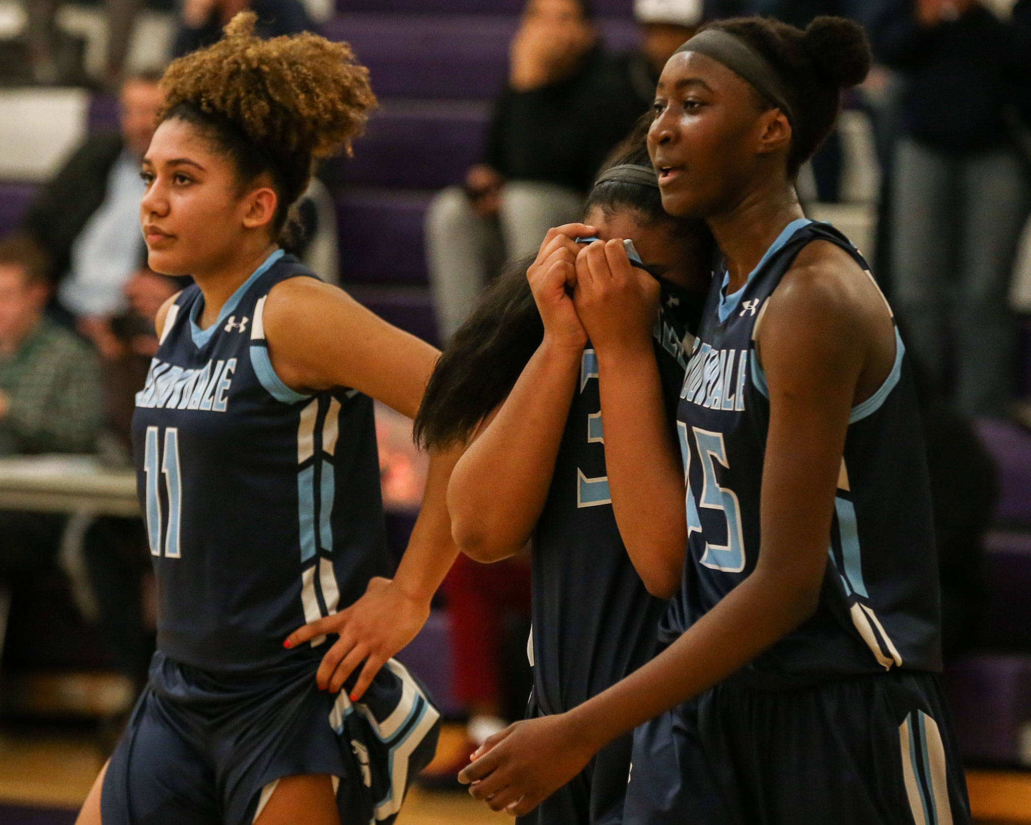 Meadowdale’s Kaisha Stark, Alicia Morrison and Fatoumata Jaiteh (left-right) leave the court after their team’s improbable postseason run ended with a 41-40 loss to West Seattle in a Class 3A state regional Friday at Garfield High School in Seattle. (Kevin Clark / The Herald)