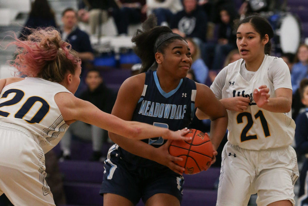 Meadowdale’s Alicia Morrison drives the lane between two West Seattle defenders. Morrison helped the Mavericks mount a massive second-half comeback. (Kevin Clark / The Herald)
