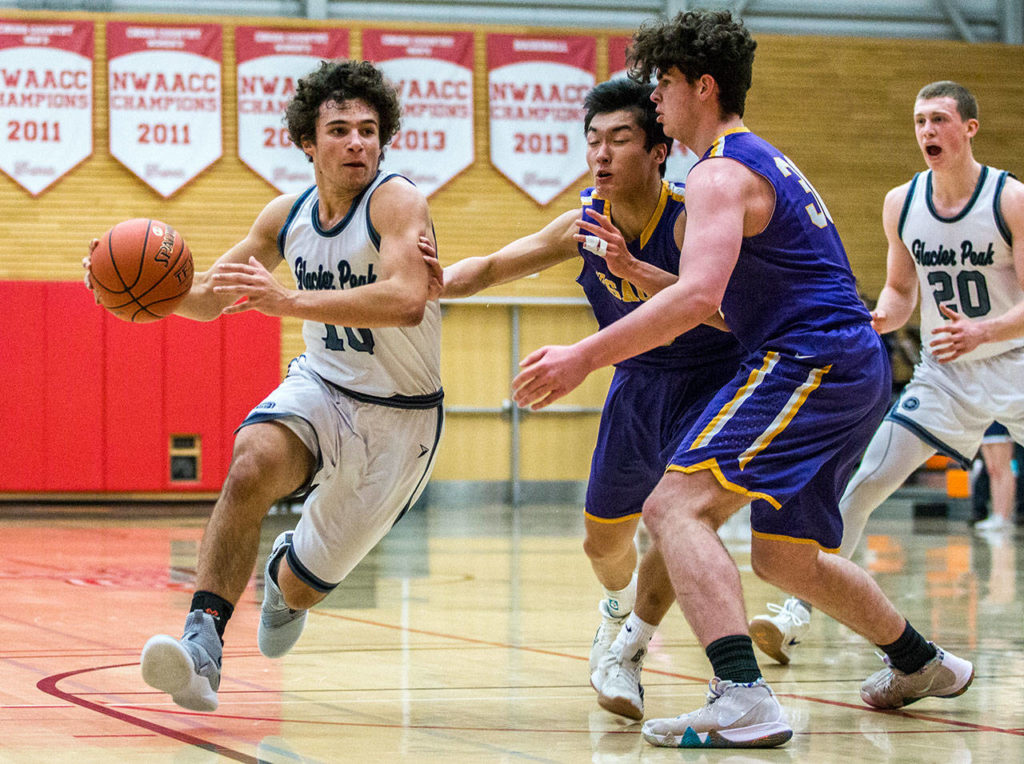 Glacier Peak’s Brayden Quantrille (left) drives to the hoop during Friday’s 4A state regional game against Issaquah at Everett Community College. (Olivia Vanni / The Herald)

