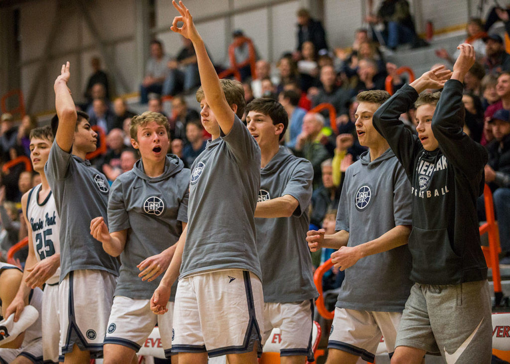 The Glacier Peak bench reacts to a teammates 3-point shot during Friday’s 4A state regional game against Issaquah at Everett Community College. (Olivia Vanni / The Herald)
