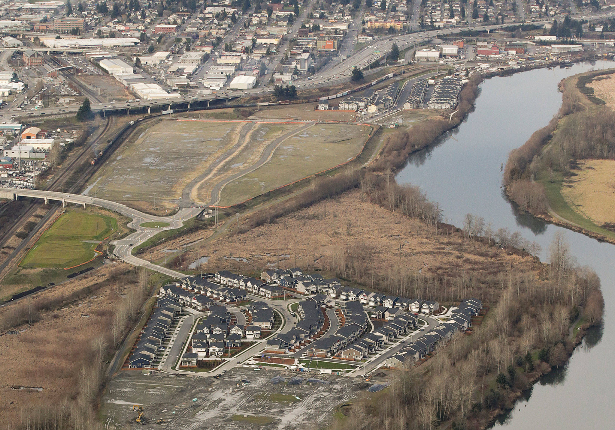 A view in January of the Riverfront development area, which consists of three parcels. On the northern parcel (top), 190 townhouses have been built. On the southern parcel (bottom), 235 single-family homes now sit. Plans for the middle, undeveloped parcel now include 1,250 housing units, 230,000 square feet of retail space, 120,000 square feet of office space and a 250-room hotel.(Andy Bronson / The Herald)