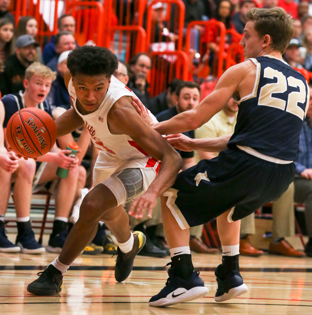 Marysville Pilchuck’s RaeQuan Battle drives the baseline with Kelso’s Dillon Davis defending during a state regional game on Feb. 23 at Everett Community College. The Tomahawks won 72-51. (Kevin Clark / The Herald)
