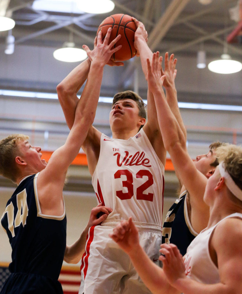 Marysville Pilchuck’s Aaron Kalab attempts a shot with Kelso’s Drew Tack (left) defending during a state regional boys basketball game Feb. 23 at Everett Community College. The Tomahawks won 72-51. (Kevin Clark / The Herald)
