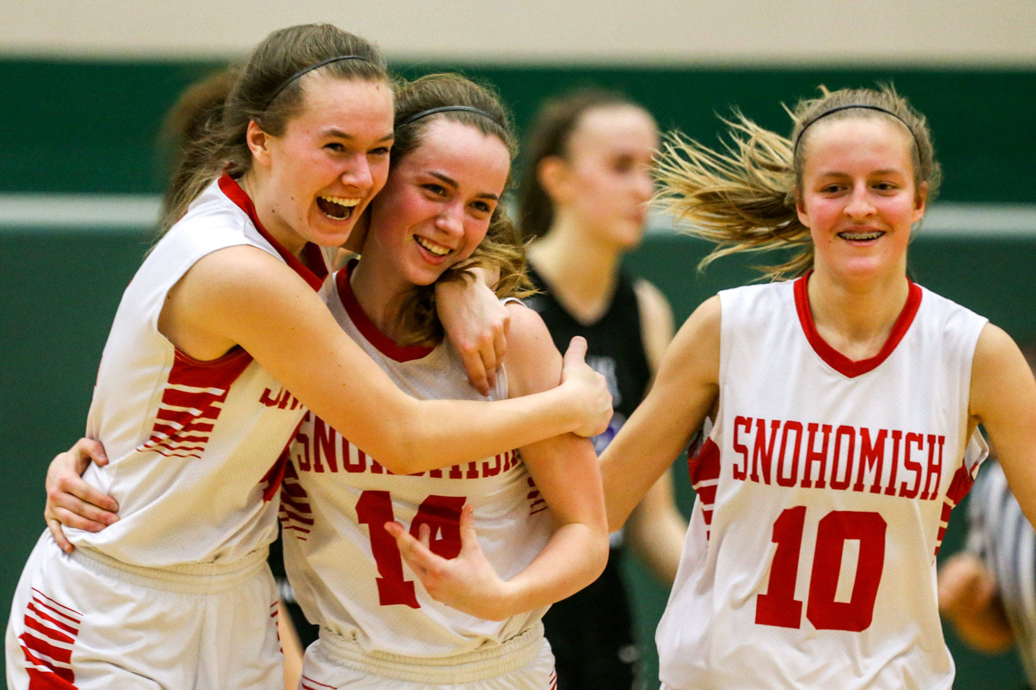 Snohomish’s Kinslee Gallatin, Maya DuChesne and Kayla Soderstrom (left-right) celebrate the Panthers’ 38-35 win over Lake Washington in a Class 3A state regional Saturday at Jackson High School in Mill Creek. The victory advanced Snohomish to the Tacoma Dome for next week’s Hardwood Classic. (Kevin Clark / The Herald)