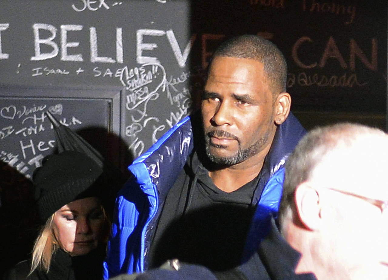 Musician R. Kelly leaves his Chicago studio Friday night, on his way to surrender to police. (Victor Hilitski/Chicago Sun-Times via AP)