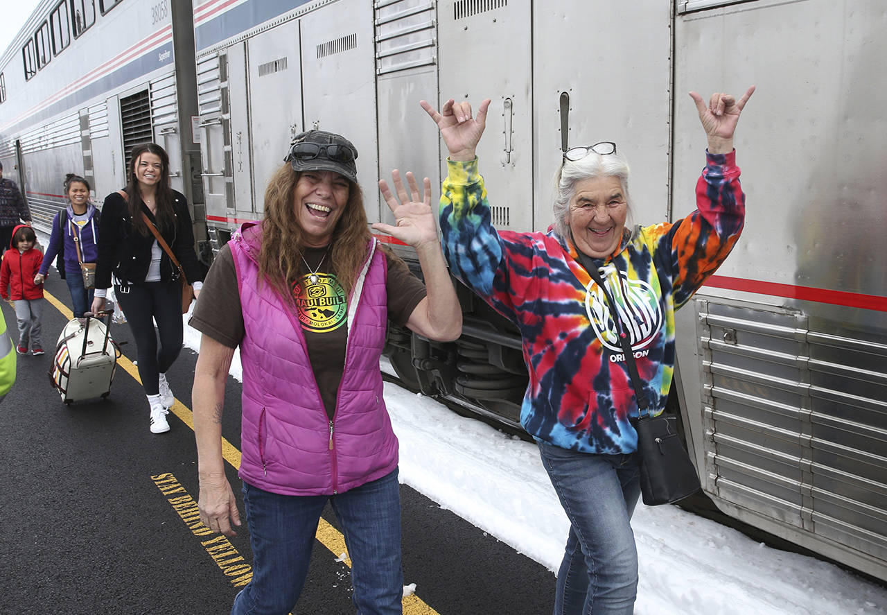 Patricia Bailey (center) and Annette Saba (right) celebrate as they disembark an Amtrak passenger train in Eugene, Oregon on Tuesday. The train traveling from Seattle to Los Angeles with 183 passengers got stranded in the snowy mountains of Oregon for at least 36 hours, putting a strain on passengers as food, patience and even diapers ran short. (AP Photo/Chris Pietsch)
