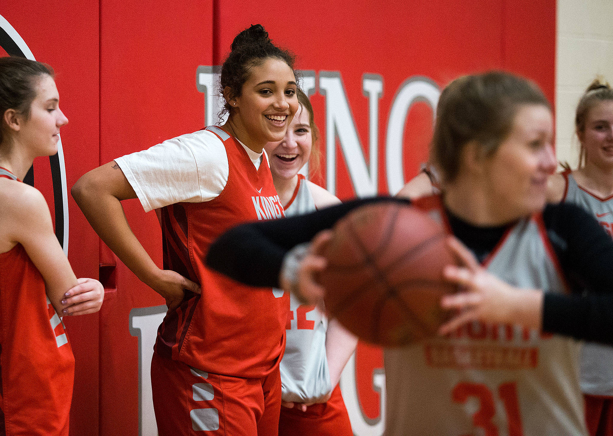 King’s freshman Jada Wynn, center, shares a laugh with her teammates during Monday’s practice. Jada, the daughter of University of Washington women’s basketball coaches Jody and Derek Wynn, averages 13.4 points per game for the state-bound Knights. (Andy Bronson / The Herald)