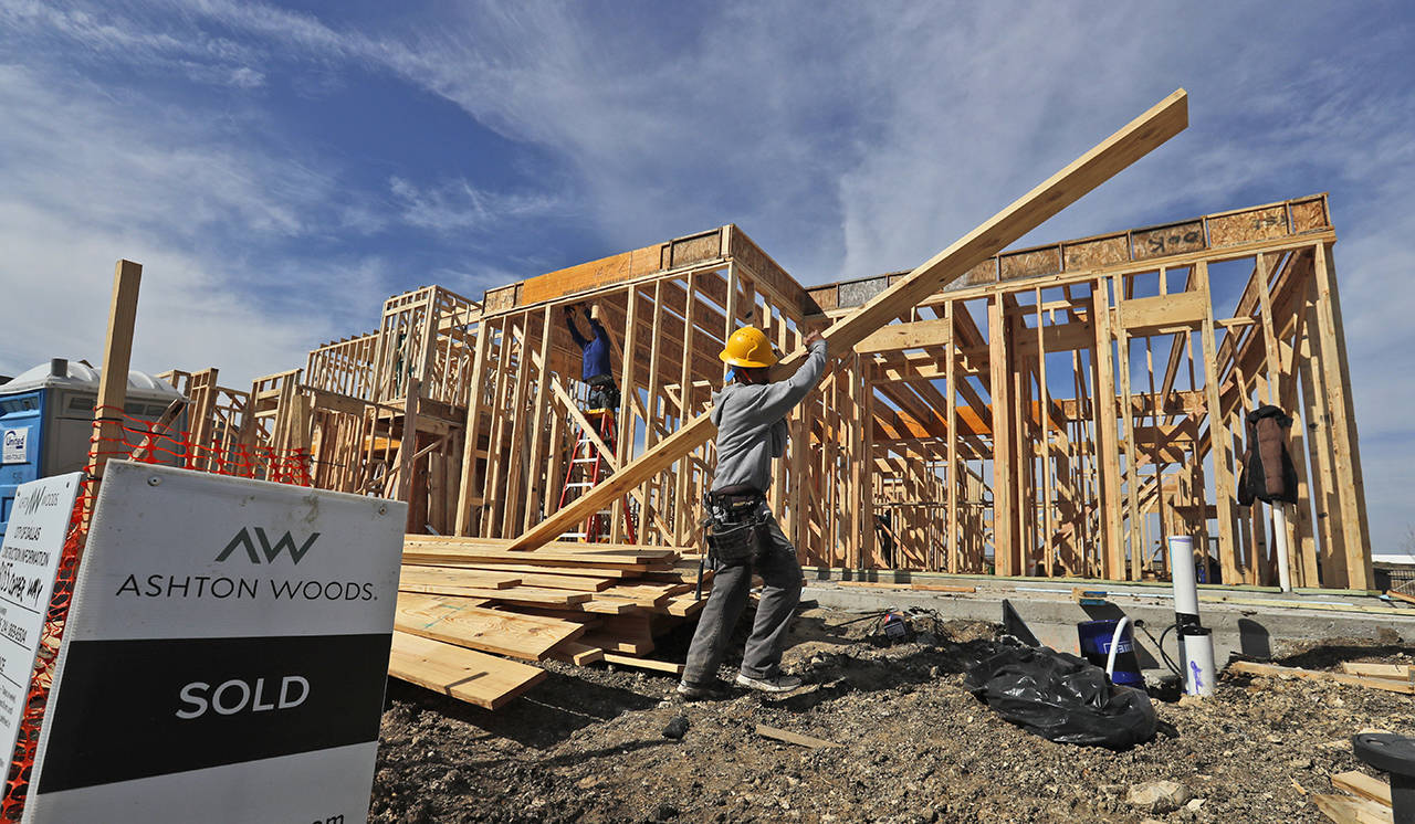 In this Feb. 20 photo, a construction crew works on an already sold new home in north Dallas. (AP Photo/LM Otero)