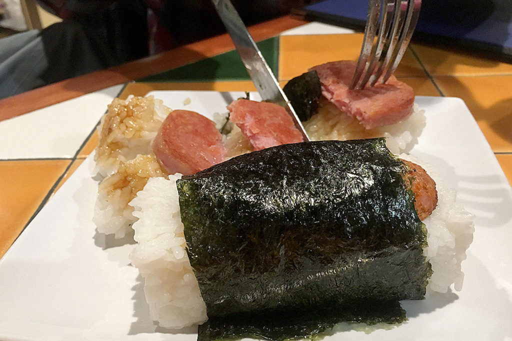 Orders of spam musubi and Portuguese musubi make for sizable appetizers of Hawaiian cuisine at Kona Kitchen in Lynnwood. Musubi is a slice of seared meat atop a bed of rice, wrapped in seaweed. (Ben Watanabe / The Herald)
