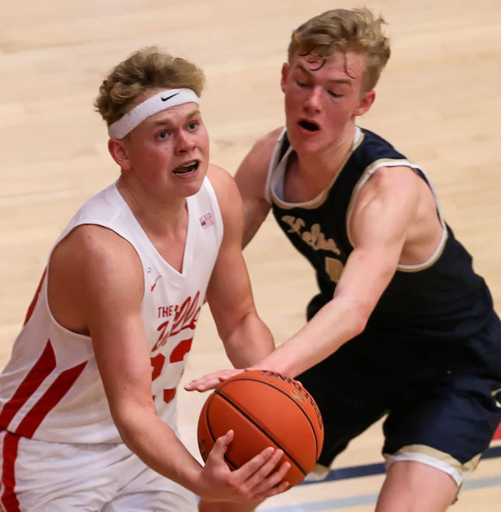 Marysville Pilchuck’s Cameron Stordahl attempts a shot with Kelso’s Drew Tack defending during a 3A state regional game on Feb. 22 at the Walt Price Student Fitness Center on the campus of Everett Community College. (Kevin Clark / The Herald)
