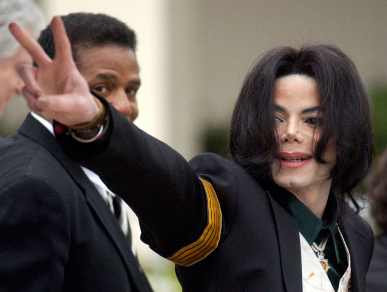 Pop icon Michael Jackson waves to his supporters as he arrives for his child molestation trial at the Santa Barbara County Superior Court in Santa Maria, California, on March 2, 2005. A new documentary premiering Sunday on HBO, “Leaving Neverland,” is about the abuse allegations of two men, Wade Robson and James Safechuck, who had previously denied Jackson molested them and supported him to authorities and in Robson’s case, very publicly. (AP Photo/Michael A. Mariant, File)