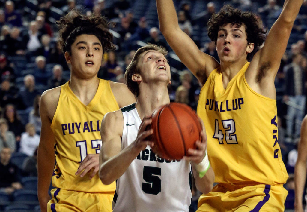 Jackson’s Ben Olesen attempts a reverse layup with Puyallup’s Luke Holcomb (left) and Dylan Rhoades defending Wednesday morning at the Tacoma Dome on February 27, 2019. The Timberwolves lost 56-50. (Kevin Clark / The Herald)
