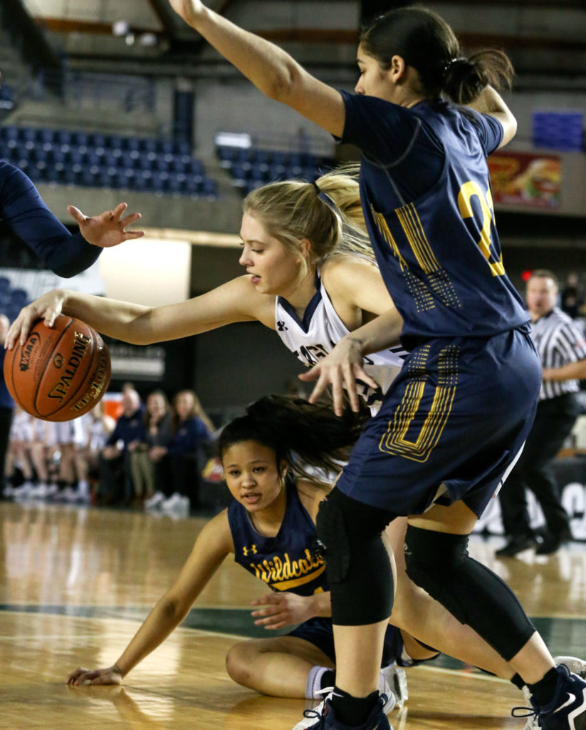 Arlington’s Abby Schwark works to control the ball with West Seattle’s Julianna Horne (right) defending and Jasmine Gayles (left) looking on Wednesday afternoon at the Tacoma Dome on February 27, 2019. The Eagles lost 50-45. (Kevin Clark / The Herald)
