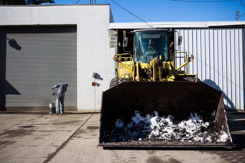 NW Washington Compost employees prep their plow again to help clear snow-covered roads in Darrington during recent storms. (Olivia Vanni / The Herald)
