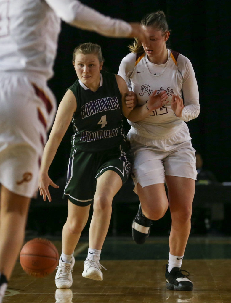 Edmonds-Woodway’s AJ Martineau brings advances the ball with Prairie’s Haley Reed on her hip Thursday morning at the Tacoma Dome on February 28, 2019. The Warriors lost 58-39.(Kevin Clark / The Herald)

