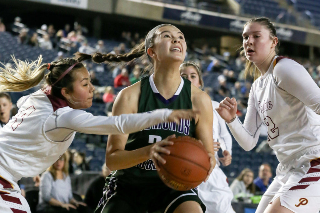 Edmonds-Woodway’s Rebekah Dasalla drives the baseline with Prairie’s Allison Corral reaching in with Haley Reed looking on Thursday morning at the Tacoma Dome on February 28, 2019. The Warriors lost 58-39.(Kevin Clark / The Herald)
