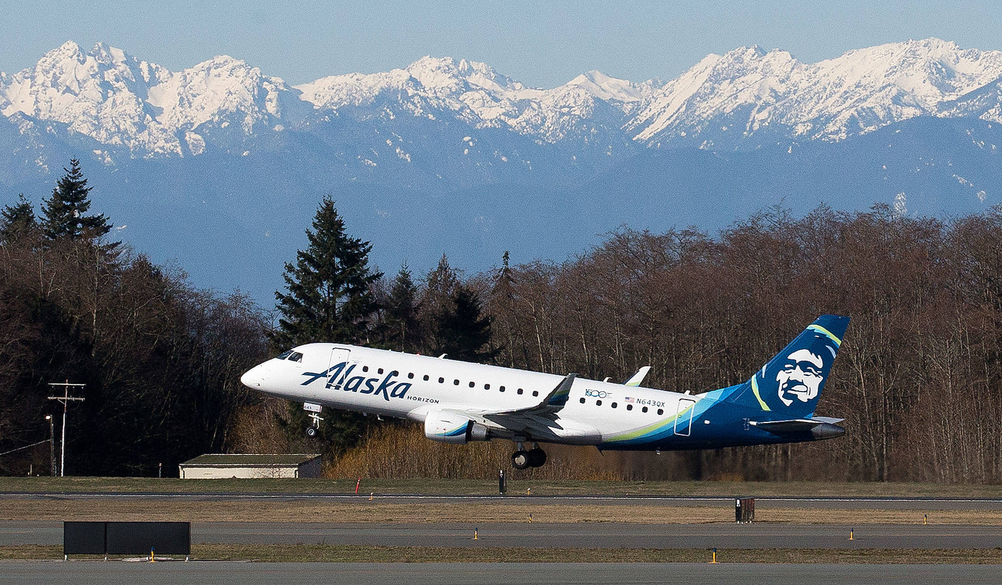 With the Olympic Mountains in the background, Alaska Airlines Flight 2878 departs for Portland on Monday, the opening day of the Paine Field passenger terminal. (Andy Bronson / The Herald)