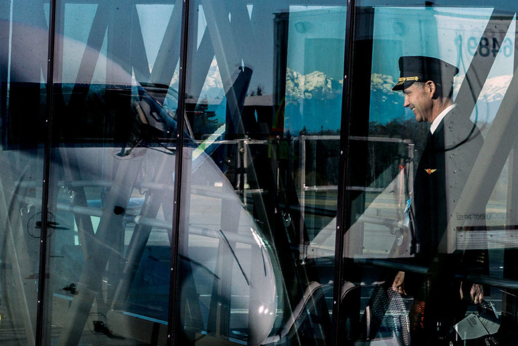 A pilot begins boarding the first plane scheduled during the grand opening of the Paine Field passenger terminal on Monday. (Olivia Vanni / The Herald)
