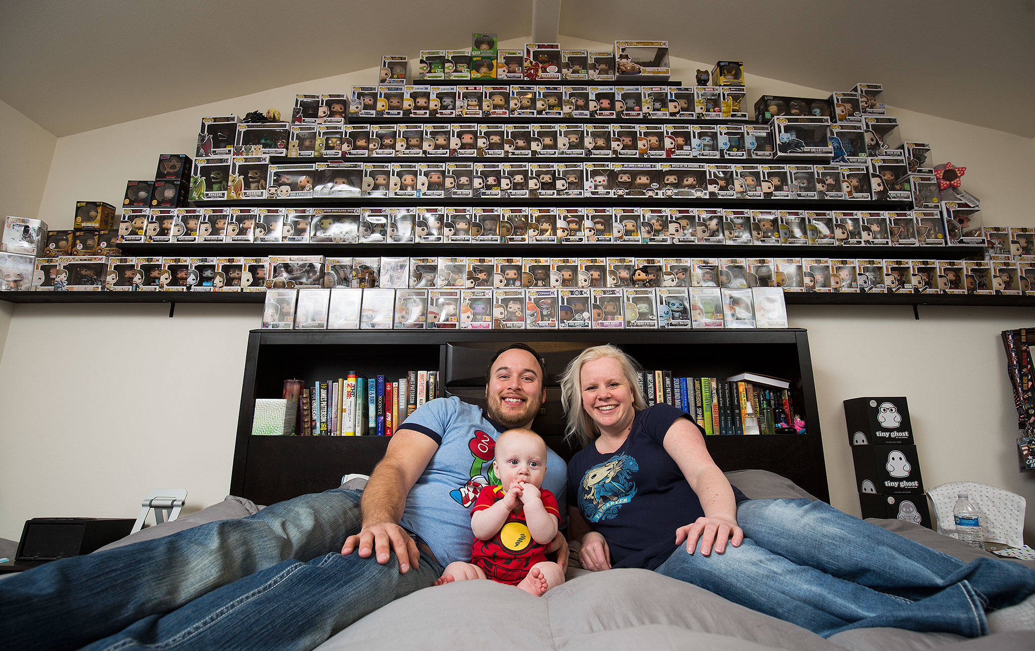 Diedre Twitty, her boyfriend Jordon Vargas and son Jensen Vargas pose user a shelf full of Funko dolls. (Andy Bronson / The Herald)