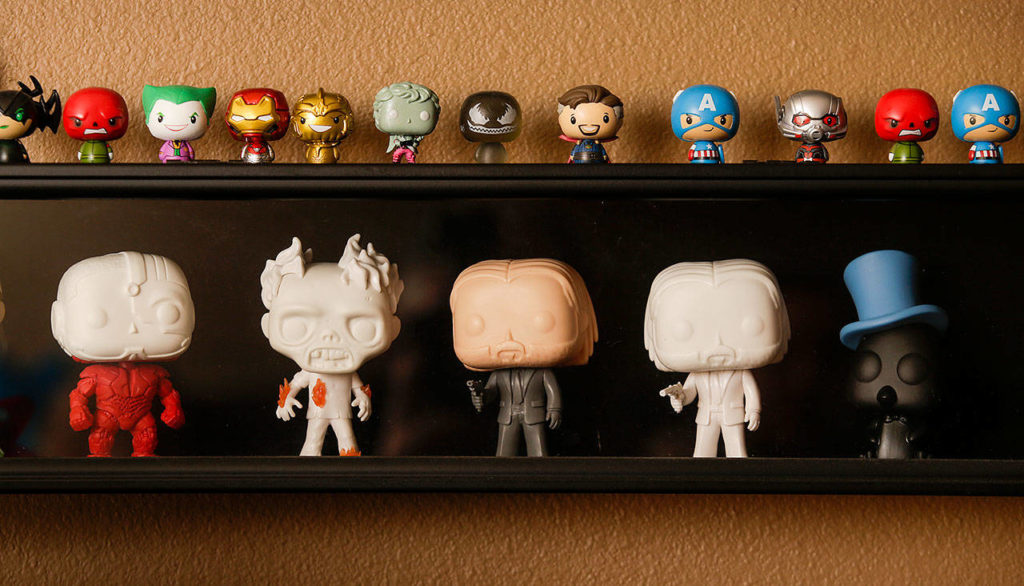 Five prototype Funko dolls are displayed in a shadow box along with miniature figures. (Andy Bronson / The Herald)
