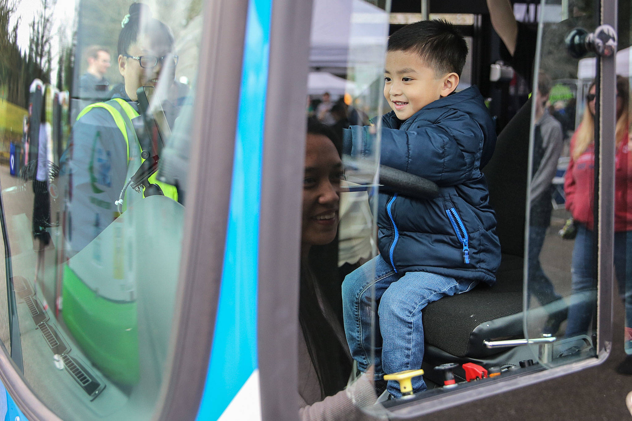 Nathan Ichiro Cercenia, 3, tries out the driver’s seat during the kickoff celebration Sunday for the Swift Green Line at McCollum Park in south Everett. (Kevin Clark / The Herald)