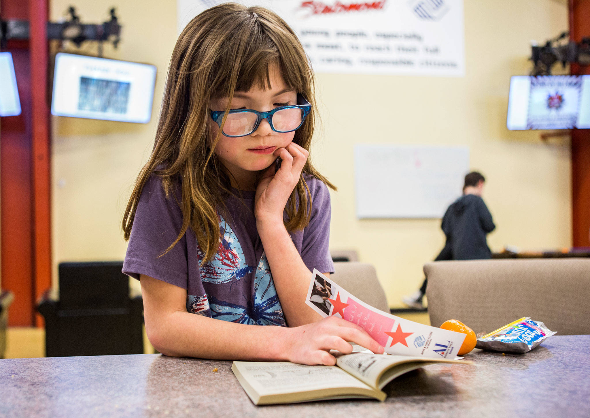 Sierra Ford, 9, reads “Bloomin Rainforest”, a book she picked out during the Assistance League of Everett’s book donation event at the Granite Falls Boys & Girls Club on Thursday in Granite Falls. (Olivia Vanni / The Herald)