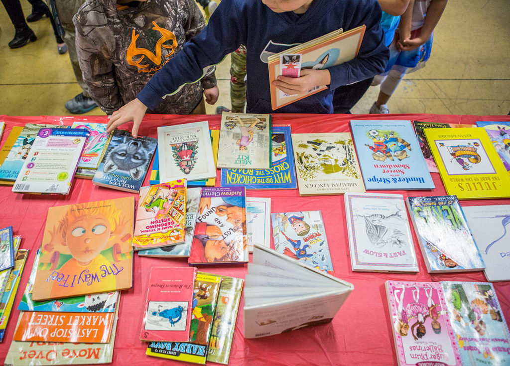 Kids pick out books during the Assistance League of Everett’s book donation event at the Granite Falls Boys & Girls Club on Thursday. (Olivia Vanni / The Herald)
