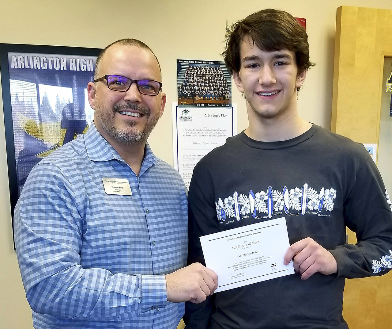 Arlington High School Senior Cole Hahn receives a certificate from principal Duane Fish. Cole is a finalist for the National Merit Scholarship, a nationwide academic competition for recognition and scholarships. (Submitted photo)