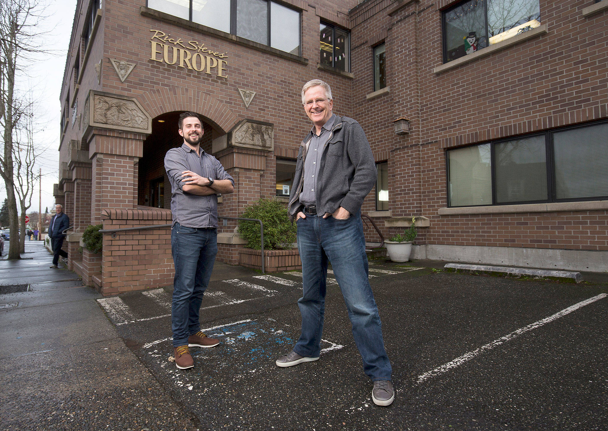 Father-and-son travel experts Rick (right) and Andy Steves stand in front of Rick Steves’ Europe headquarters in downtown Edmonds. (Andy Bronson / The Herald)