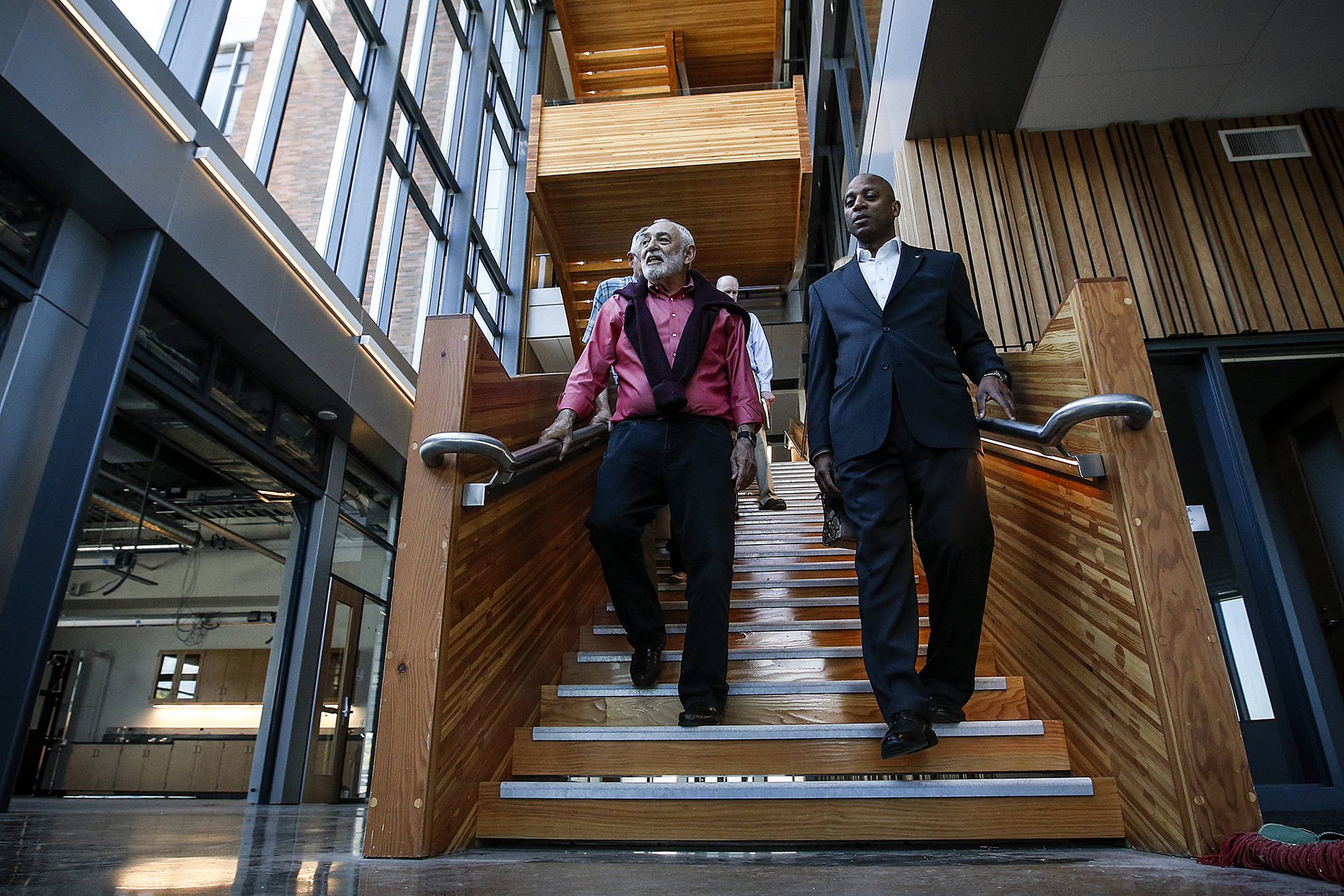 Dr. Larry Schecter (left), associate dean for WSU North Puget Sound’s medical education programs, walks down the central staircase in May, 2017, with Chancellor Paul Pitre in the building that houses the medical school’s programs in Everett. (Ian Terry / Herald file photo)
