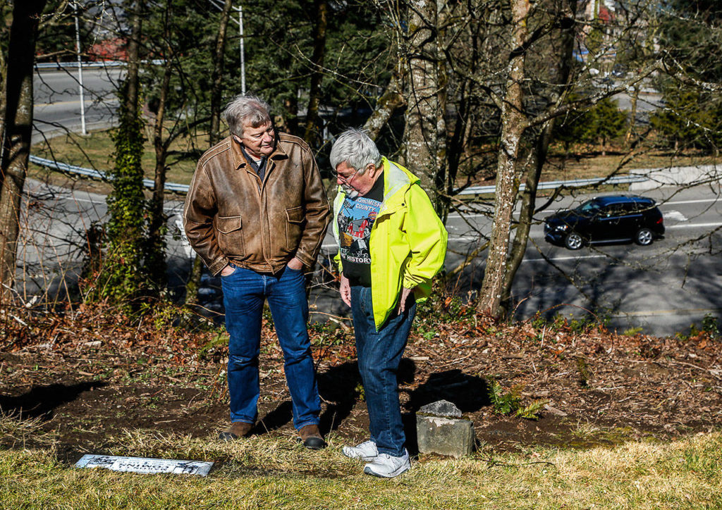 Author J.D. Howard (left) and Fred Cruger at the new gravestone for Martin Comins. Cruger, a Granite Falls Historical Society board member, helped Howard with research for the new historical novel “The Pride of Monte Cristo.” (Dan Bates / The Herald)
