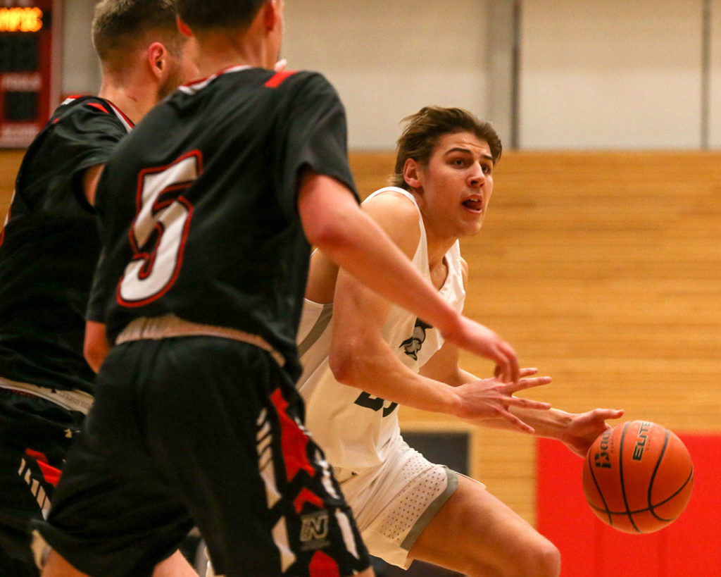 Everett Community College’s Magnus Jespersen drives against Olympic’s Calvin Dennis (left) and Izaiah Clark during an NWAC men’s basketball game on Feb. 20 in Everett. (Kevin Clark / The Herald)
