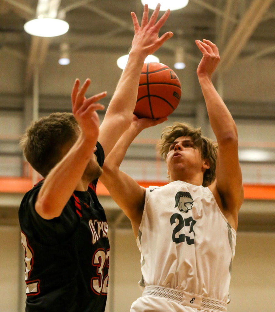 Everett Community College’s Magnus Jespersen (right) shoots over Olympic’s Calvin Dennis during a Feb. 20 NWAC men’s basketball game in Everett. (Kevin Clark / The Herald)
