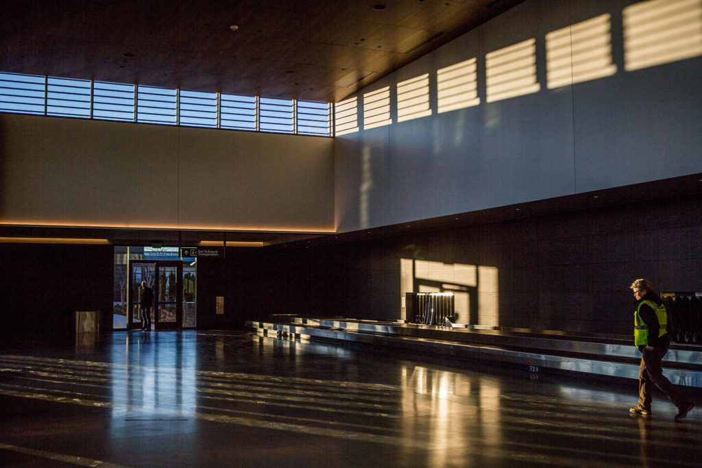People walk through the baggage claim area during the grand opening of the Paine Field Airport on Monday in Everett. (Olivia Vanni / The Herald)
