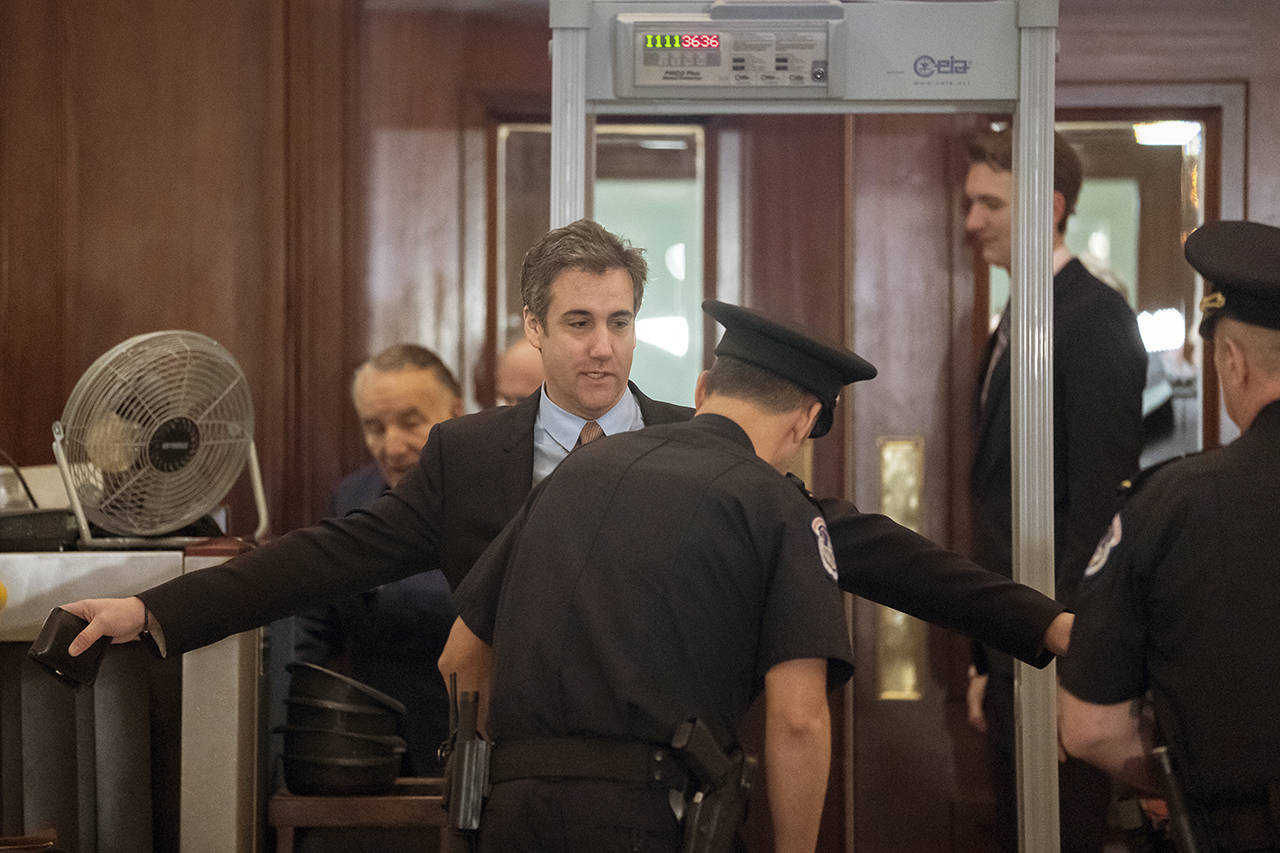 Michael Cohen, President Donald Trump’s former lawyer, is screened by U.S. Capitol Police officers as he returns for a fourth day of testimony as Democrats pursue a flurry of investigations into Trump’s White House, businesses and presidential campaign, at the Capitol in Washington on Wednesday. (AP Photo/J. Scott Applewhite)
