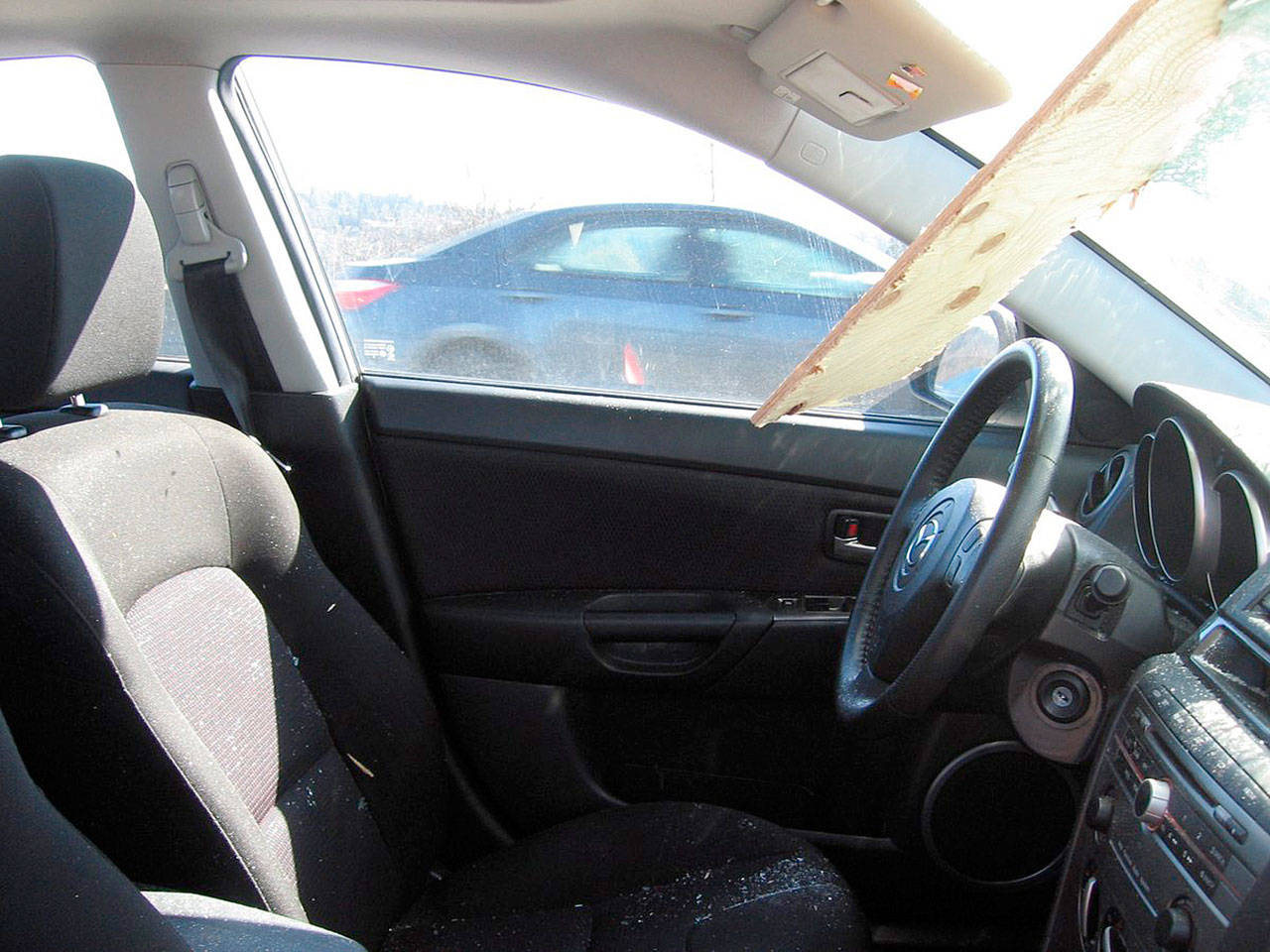 A driver suffered only minor scratches from glass splinters after a piece of lumber from an unsecured load went through his windshield Tuesday along Highway 167. (Washington State Patrol)