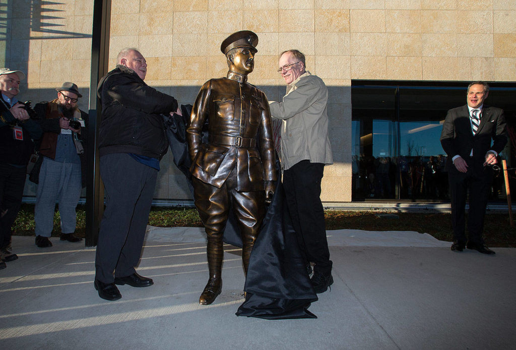 Grand-nephews Nicholas Moe (left) and Tom Paine unveil a statue of Lt. Topliff Olin Paine on opening day of the Paine Field terminal on Monday in Everett. (Andy Bronson / The Herald)
