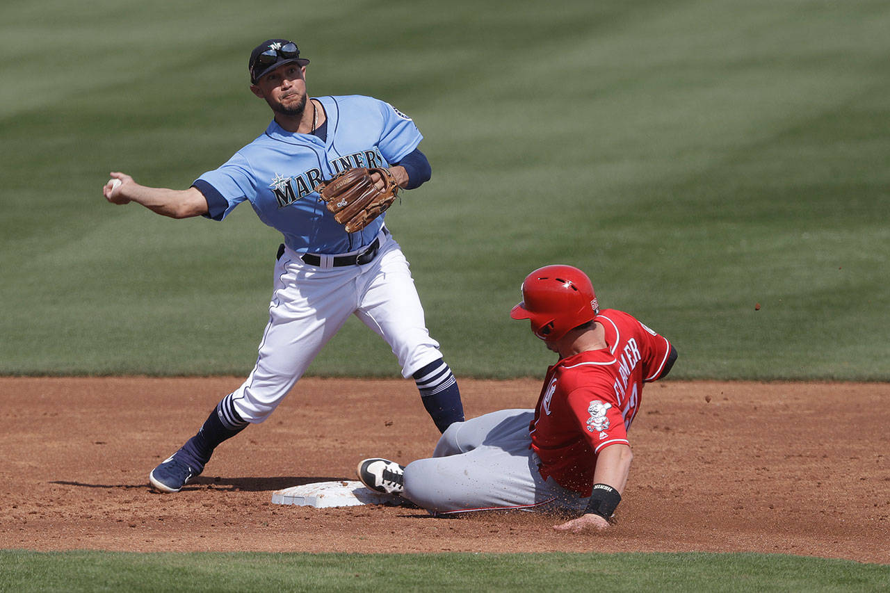 The Reds’ Kyle Farmer is forced out at second as the Mariners’ Kristopher Negron throws to first for a double play during the second inning of a spring game on Feb. 25, 2019, in Peoria, Ariz. (AP Photo/Darron Cummings)