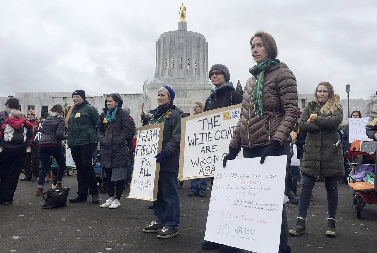 Hundreds of people, including families, attend a rally at the Oregon State Capitol protesting a proposal to tighten school vaccine requirements Thursday in Salem, Oregon. (AP Photo/Sarah Zimmerman)