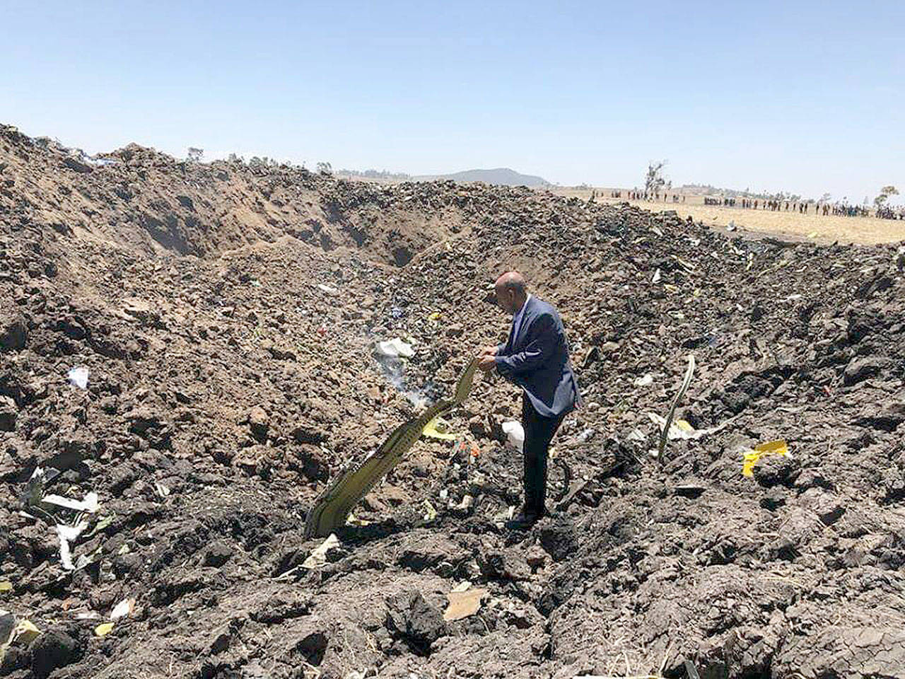 In this photo taken from the Ethiopian Airlines Facebook page, the CEO of Ethiopian Airlines, Tewolde Gebremariam, looks at the wreckage of the plane that crashed shortly after takeoff from Addis Ababa, Ethiopia, Sunday March 10. All 157 people thought to be on board died, the airline and state broadcaster said, as anxious families rushed to airports in Addis Ababa and the destination, Nairobi. (Facebook via AP)