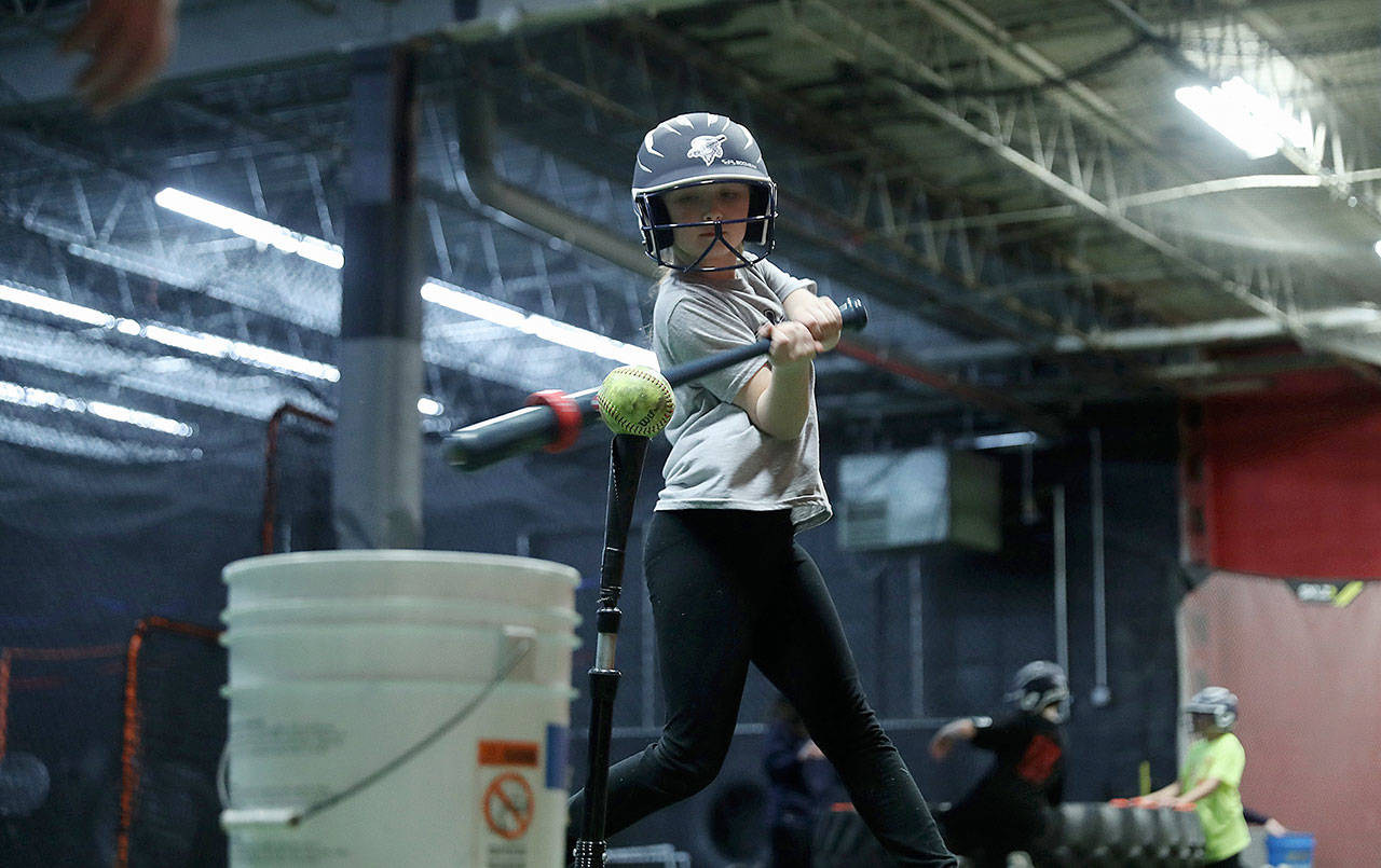 Marie Marcum, 9, works on her swing during practice with her softball team in Joliet, Ill. (John J. Kim / Chicago Tribune)