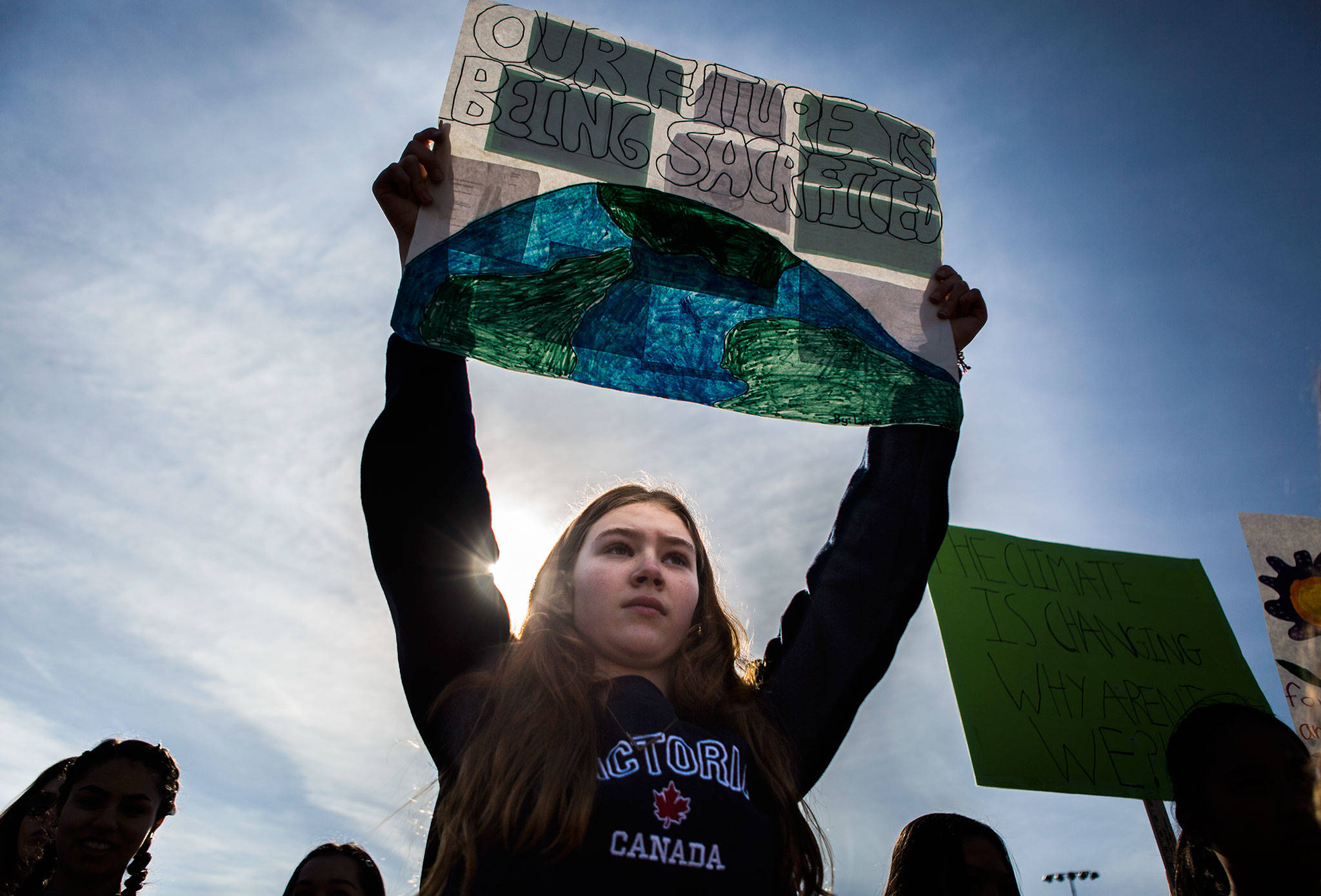 Maeve McArdle, 12, from TOPS (The Option Program at Seward) School, holds a sign that reads “Our future is being sacrificed” during the student-led Youth Climate Strike at Cal Anderson Park in Seattle on Friday. (Olivia Vanni / The Herald)